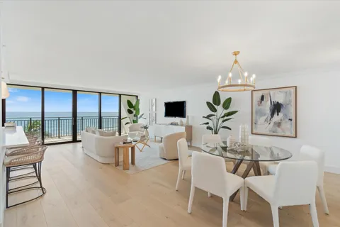 a living room with furniture two large windows and a flat screen tv