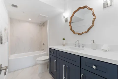 a bathroom with a sink a toilet and a mirror