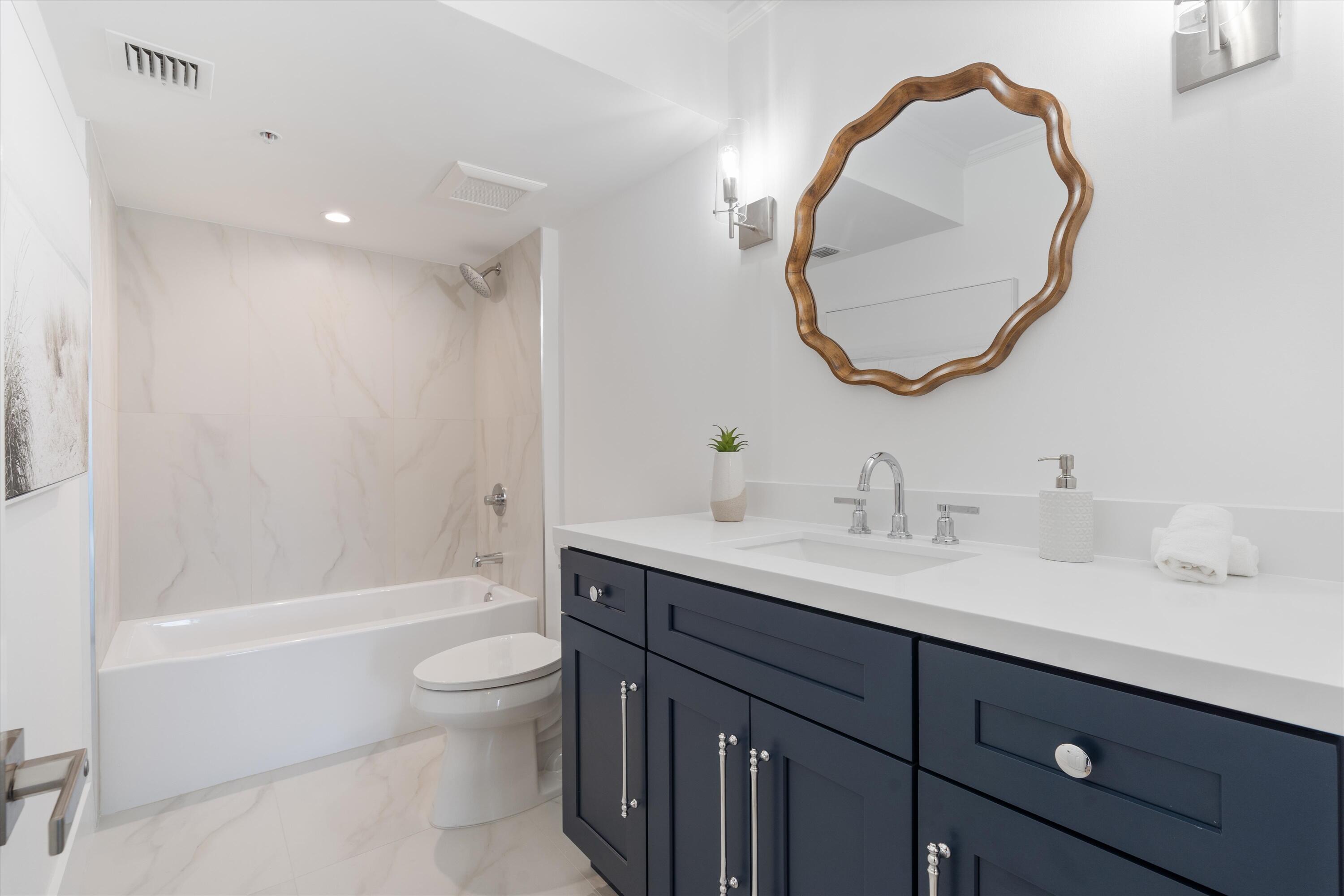 1800 South Ocean Boulevard, Unit 4B Boca Raton, FL 33432 - Photo 24 of 39 a bathroom with a sink a toilet and a mirror