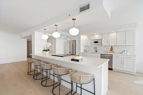 a kitchen with a dining table chairs sink and cabinets