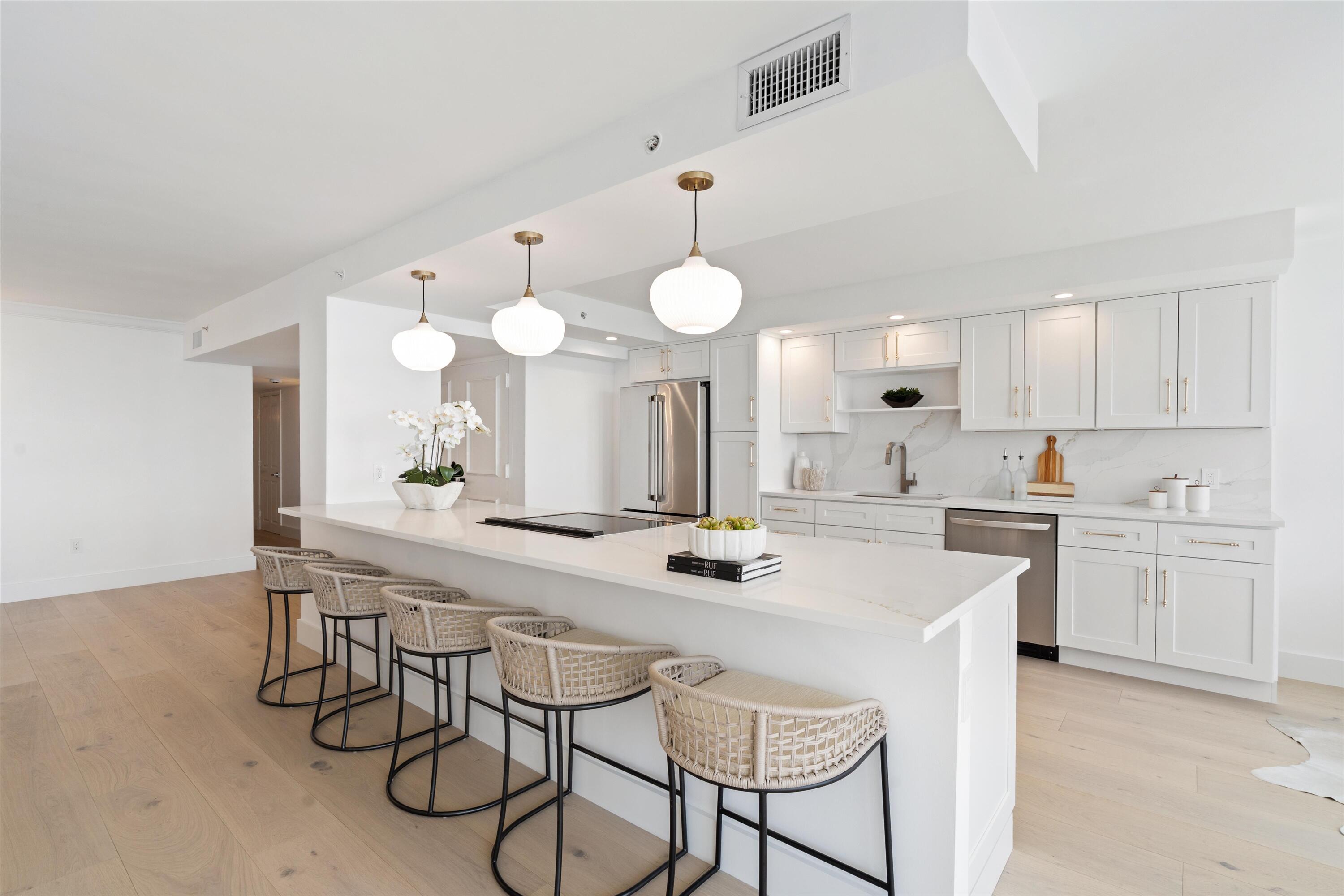 1800 South Ocean Boulevard, Unit 4B Boca Raton, FL 33432 - Photo 8 of 39 a kitchen with a dining table chairs sink and cabinets