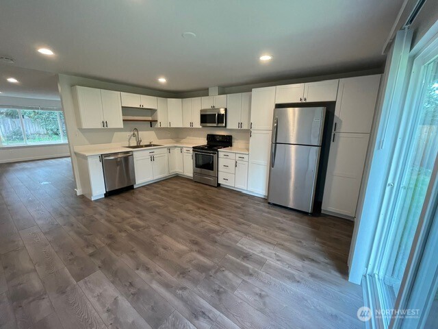 7438 Mullen Road Southeast, Unit AB Lacey, WA 98503 - Photo 19 of 37 a kitchen with a refrigerator a sink and a stove top oven