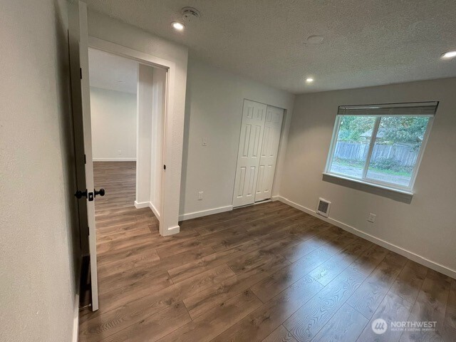 7438 Mullen Road Southeast, Unit AB Lacey, WA 98503 - Photo 21 of 37 an empty room with wooden floor and windows