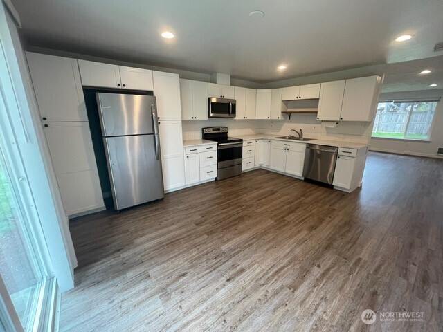 7438 Mullen Road Southeast, Unit AB Lacey, WA 98503 - Photo 8 of 37 a kitchen with a refrigerator a sink and a stove top oven