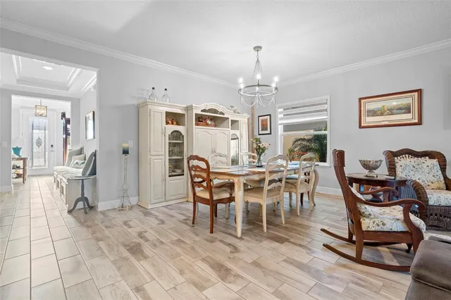 a living room with furniture dining table and a chandelier