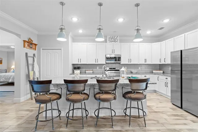 a kitchen with granite countertop white cabinets and a stove top oven