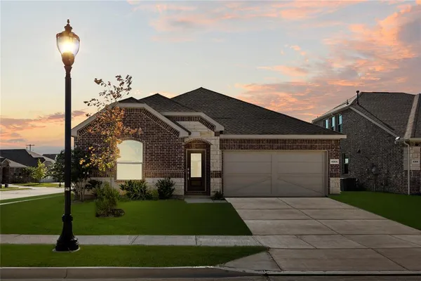 a front view of a house with a yard and trees