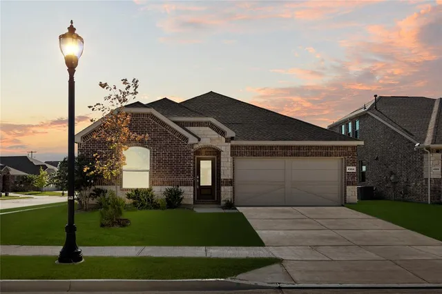 a front view of a house with a yard and trees