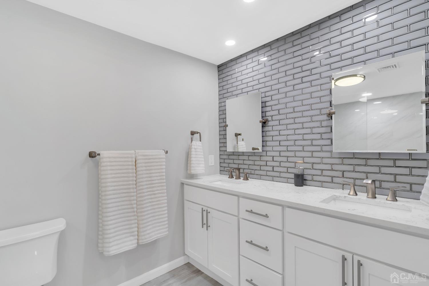 116 Grovers Mill Road Plainsboro, NJ 08536 - Photo 39 of 78 a bathroom with a sink a toilet and a large mirror