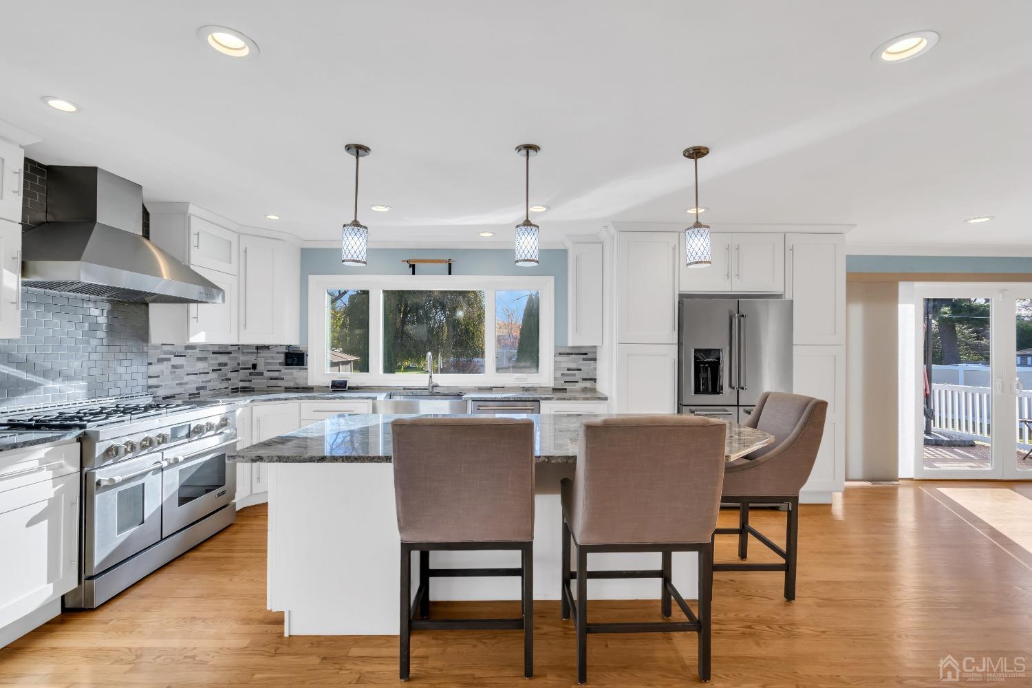 116 Grovers Mill Road Plainsboro, NJ 08536 - Photo 4 of 78 a kitchen with stainless steel appliances granite countertop a stove top oven a sink dishwasher a dining table and chairs with wooden floor