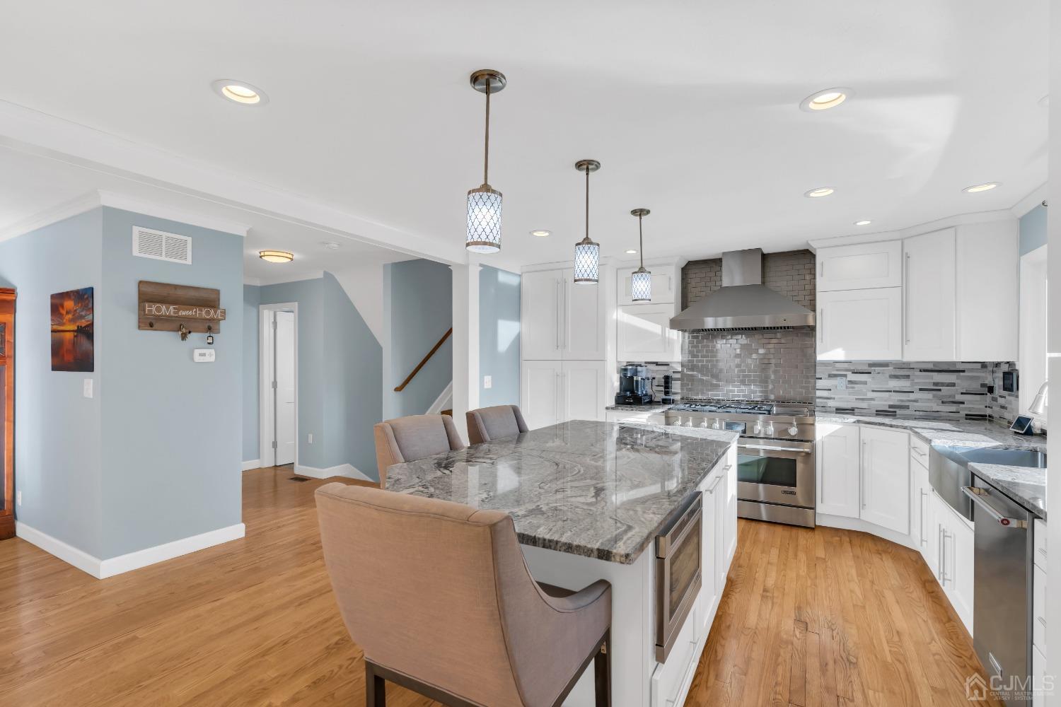 116 Grovers Mill Road Plainsboro, NJ 08536 - Photo 10 of 78 a kitchen with kitchen island a stove a sink a refrigerator and a dining table with wooden floor