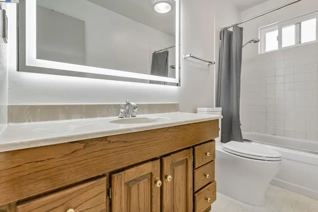 a bathroom with a sink a toilet a mirror and shower