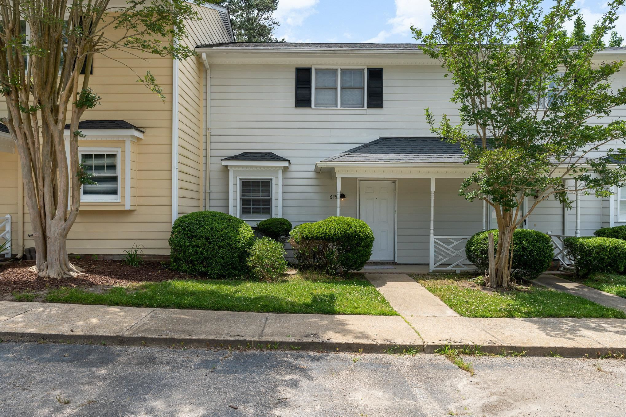 a front view of a house with a garden and plants