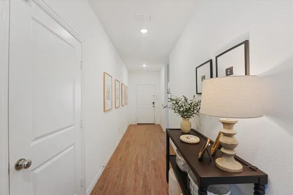 a view of a hallway with furniture and wooden floor