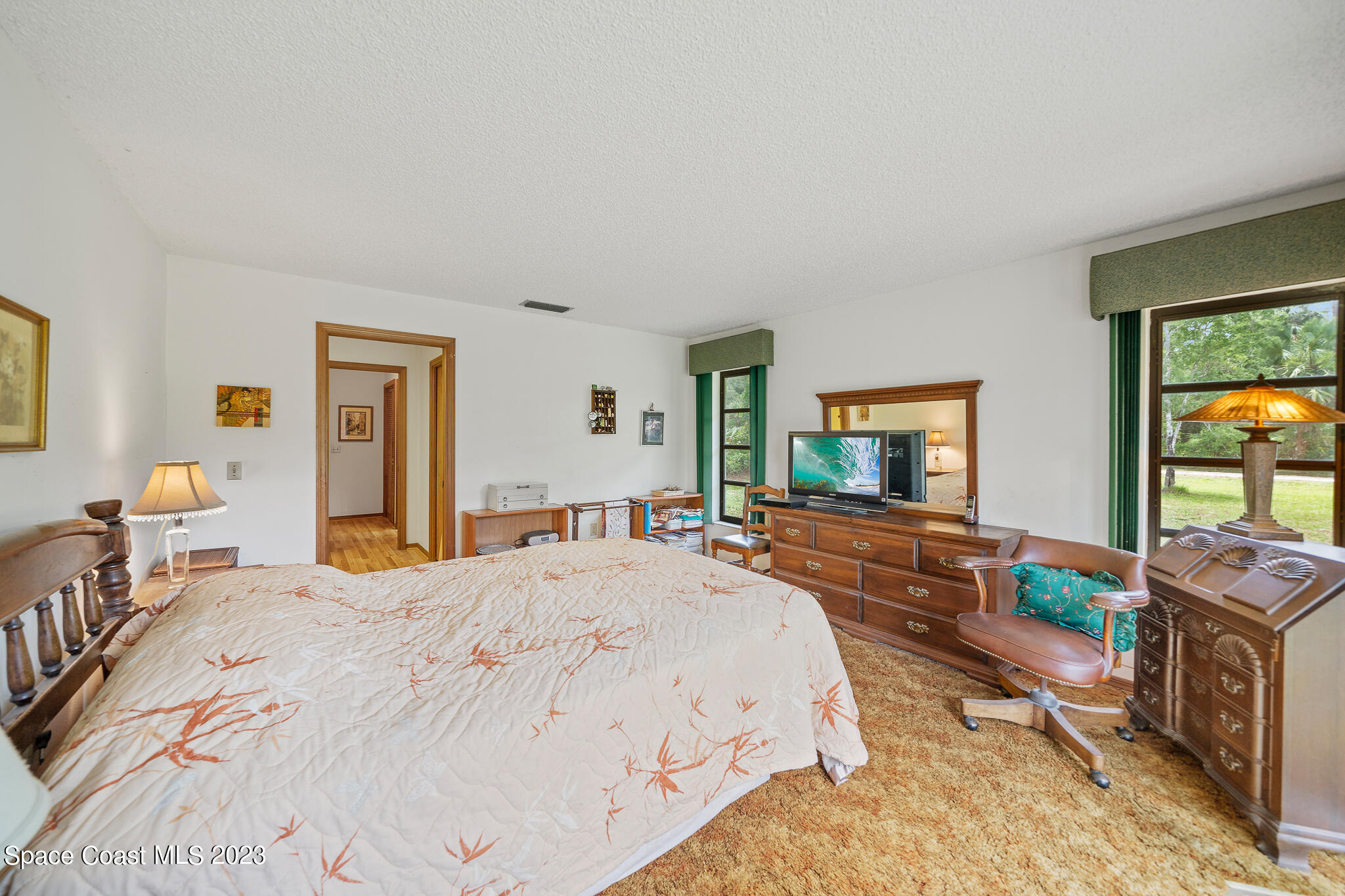 3836 Hield Road Northwest Palm Bay, FL 32907 - Photo 19 of 55 a bedroom with a bed and large windows