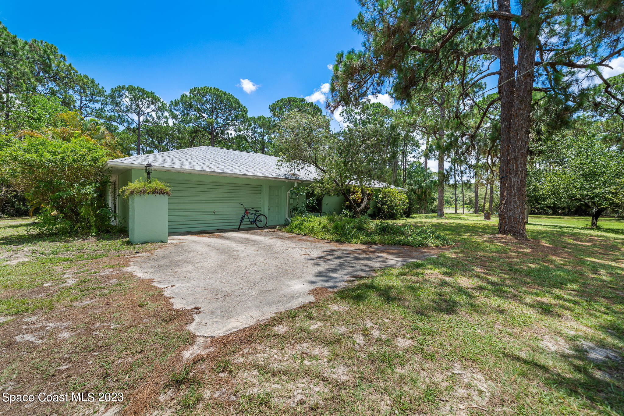 3836 Hield Road Northwest Palm Bay, FL 32907 - Photo 36 of 55 a backyard of a house with a yard and garage