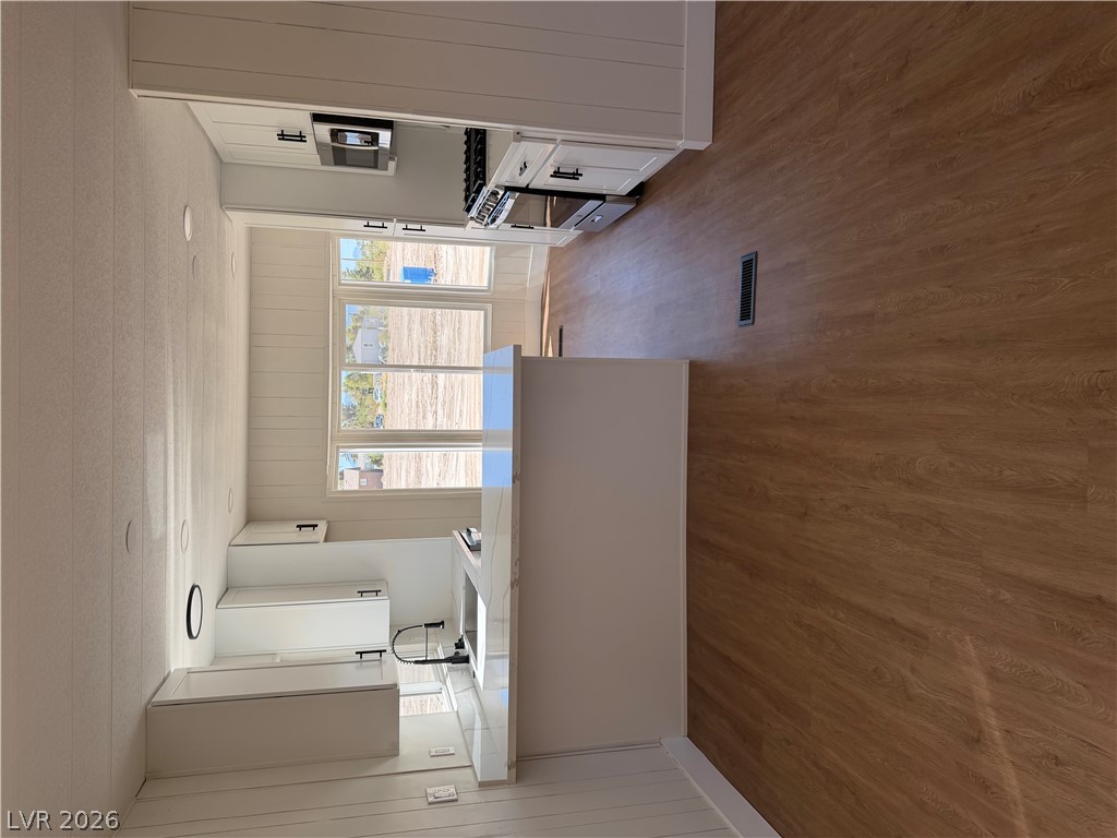 6401 Hafen Ranch Road Pahrump, NV 89061 - Photo 8 of 22 Warm wood flooring contrasts beautifully with crisp white cabinetry and stone countertops in this modern kitchen.