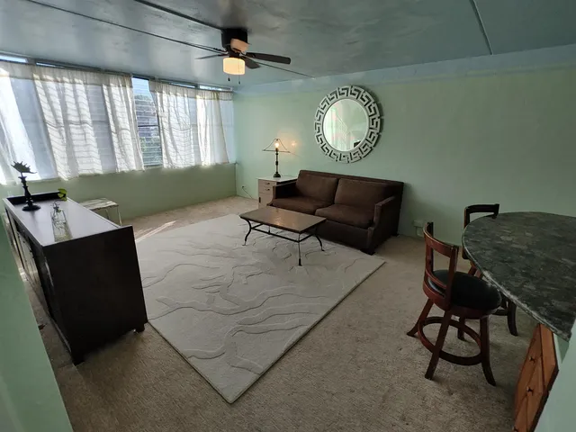 a living room with furniture a window and wall painting