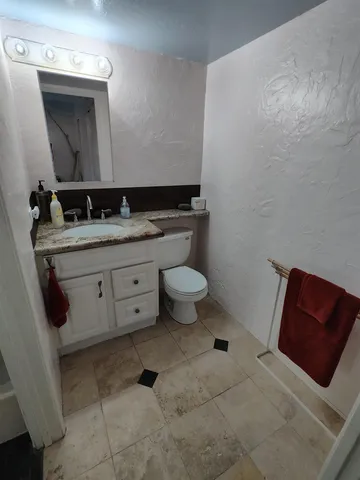 a bathroom with a toilet sink and mirror