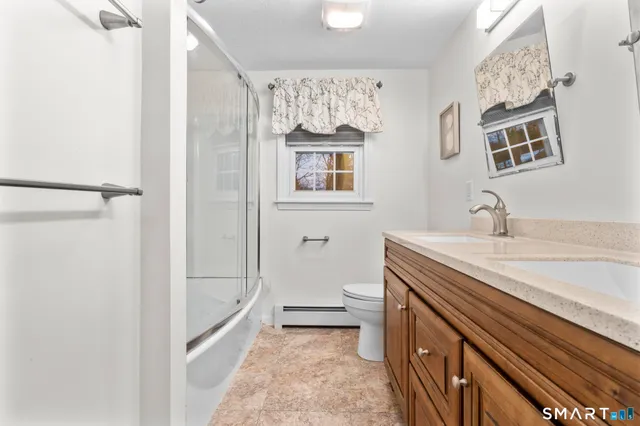 a bathroom with a tub shower vanity and a sink