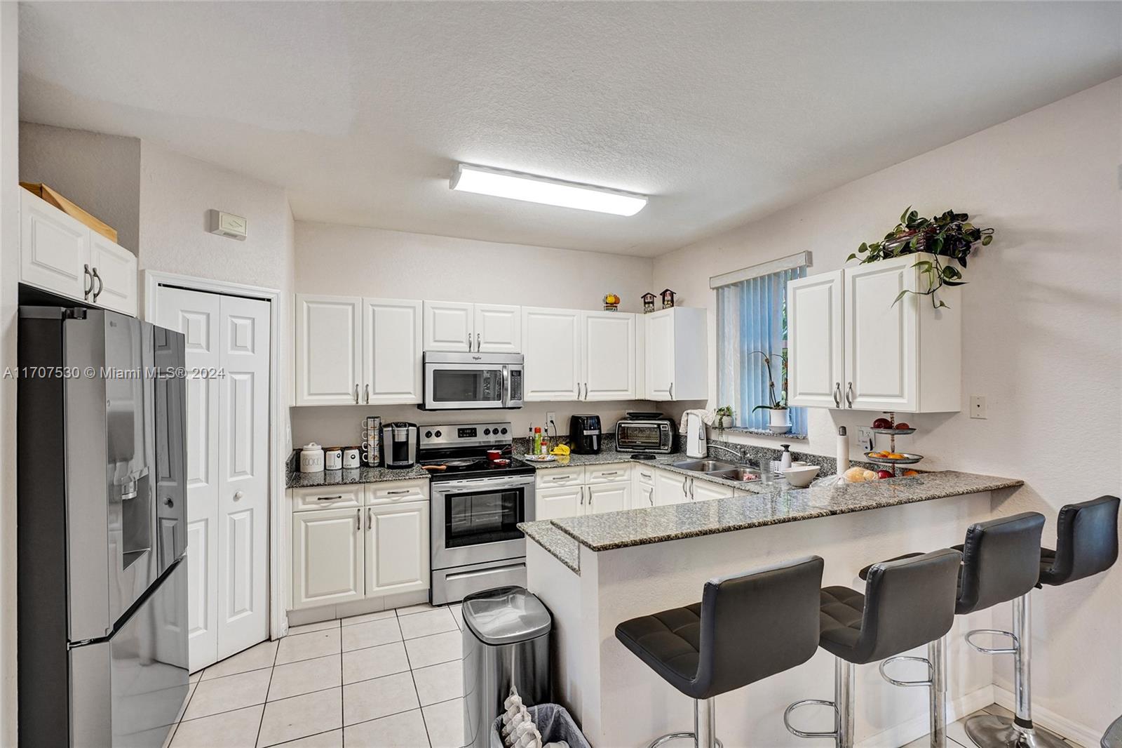 11763 Southwest 137th Path Miami, FL 33186 - Photo 13 of 27 a kitchen with appliances a sink and cabinets