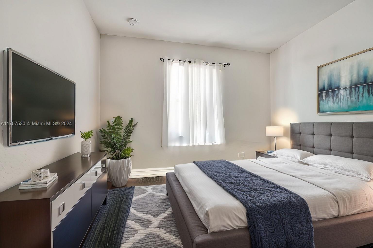 11763 Southwest 137th Path Miami, FL 33186 - Photo 8 of 27 a bedroom with a bed and a flat screen tv