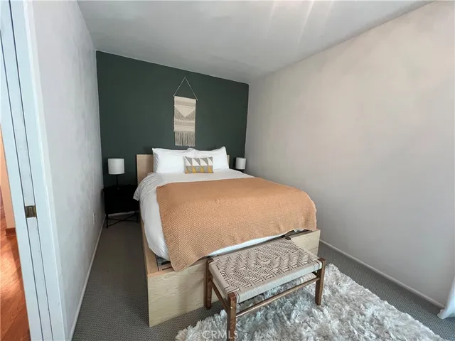 a bed sitting in a bedroom next to a window