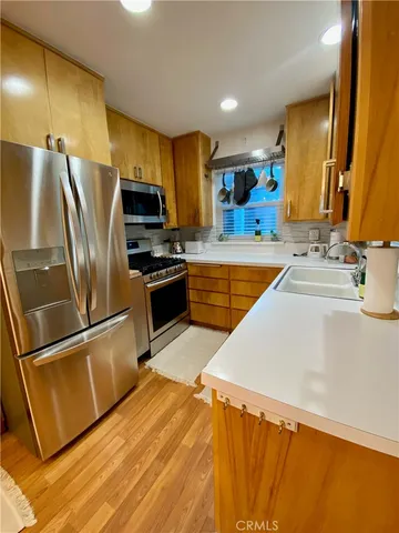 a kitchen with stainless steel appliances a refrigerator sink and microwave