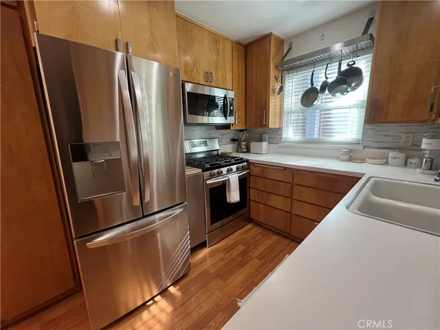 a kitchen with stainless steel appliances a refrigerator sink and microwave
