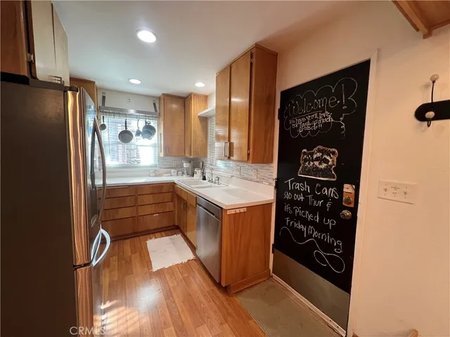 a kitchen with stainless steel appliances granite countertop a refrigerator and a sink