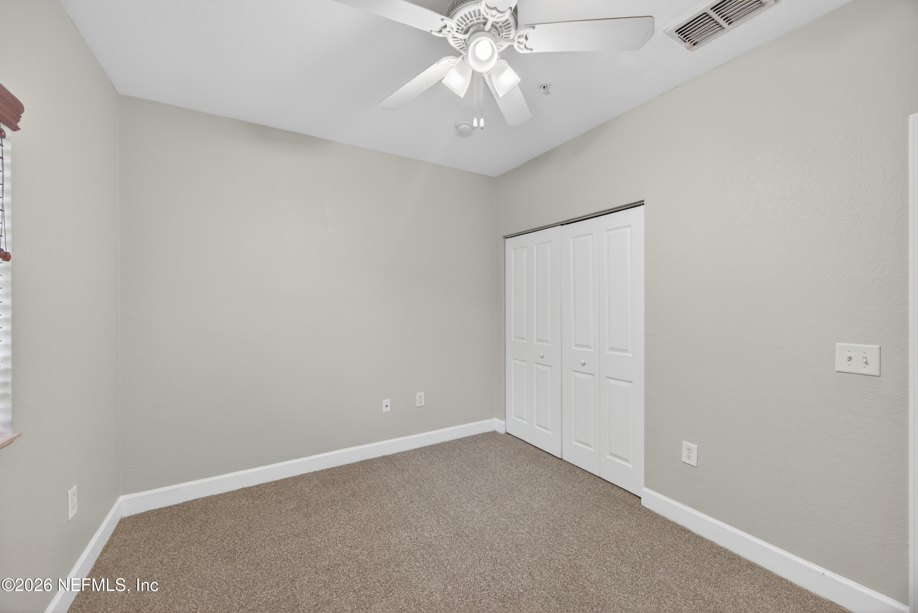 9745 Touchton Road, Unit 1224 Jacksonville, FL 32246 - Photo 17 of 22 an empty room with a chandelier fan and windows