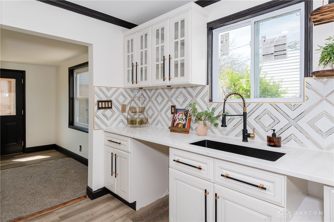 5240 Haverfield Road Dayton, OH 45432 - Photo 20 of 58 This bright kitchen features sleek white cabinetry and a patterned backsplash, creating an inviting atmosphere.