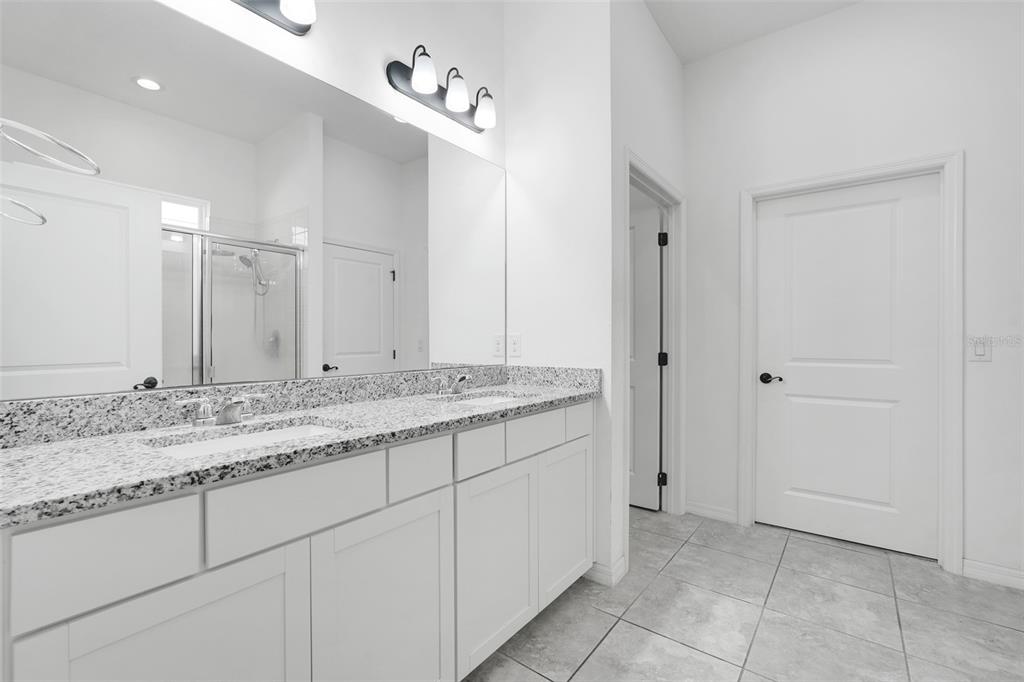 1807 Sunfish Street St. Cloud, FL 34771 - Photo 17 of 27 a bathroom with a granite countertop sink and a mirror