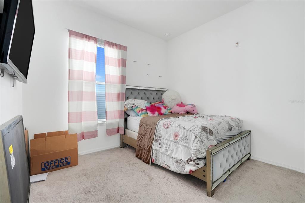 1807 Sunfish Street St. Cloud, FL 34771 - Photo 20 of 27 a bed sitting in a bedroom next to a window