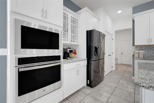 a large white kitchen with cabinets