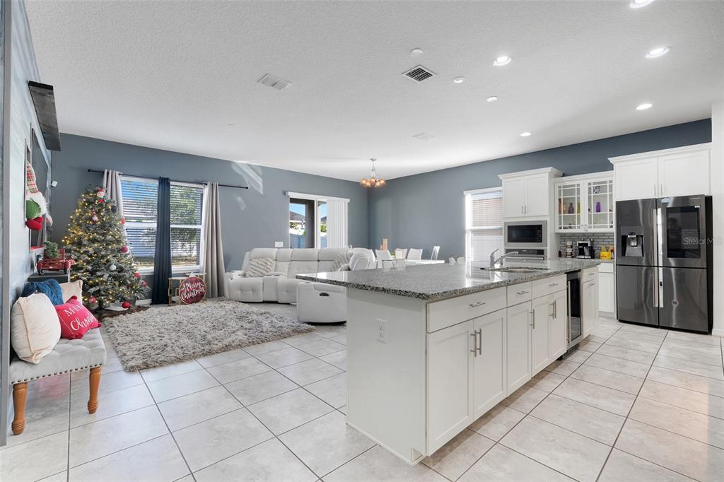 1807 Sunfish Street St. Cloud, FL 34771 - Photo 9 of 27 a large white kitchen with stainless steel appliances kitchen island granite countertop a sink and cabinets