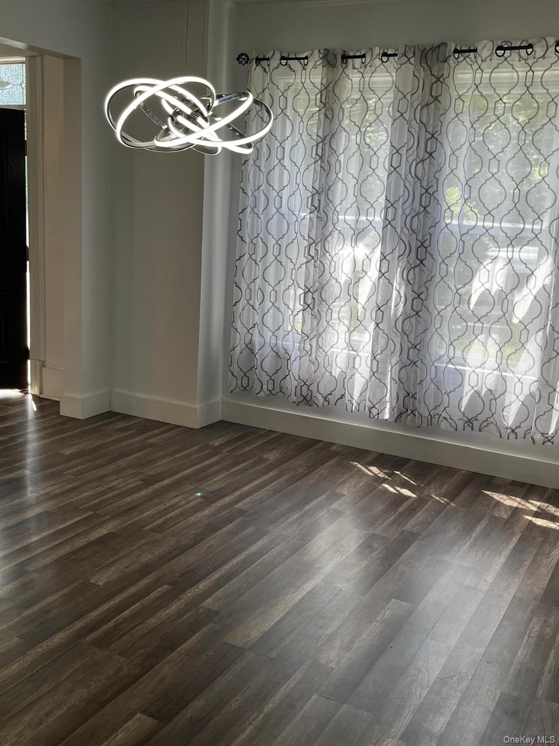 440 Mile Square Road Yonkers, NY 10701 - Photo 13 of 29 Wood-finish flooring with baseboard trim, contemporary light fixture, and window with sheer patterned curtains
