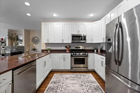 a kitchen with stainless steel appliances granite countertop a refrigerator sink and stove