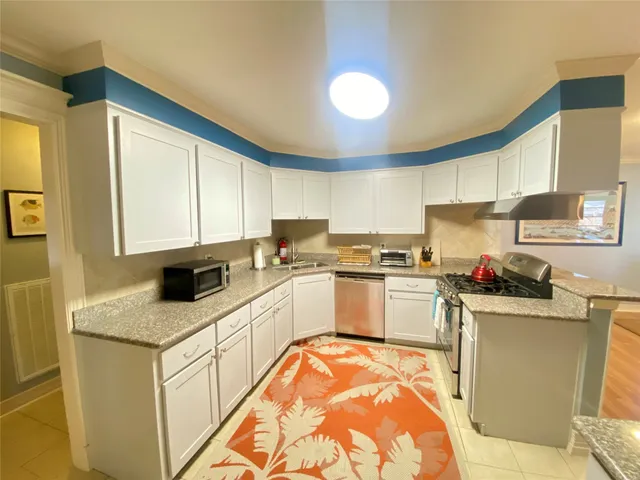a kitchen with granite countertop a sink stove and cabinets