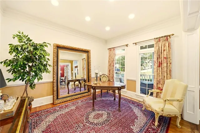 a living room with furniture a large window and a dining table with wooden floor