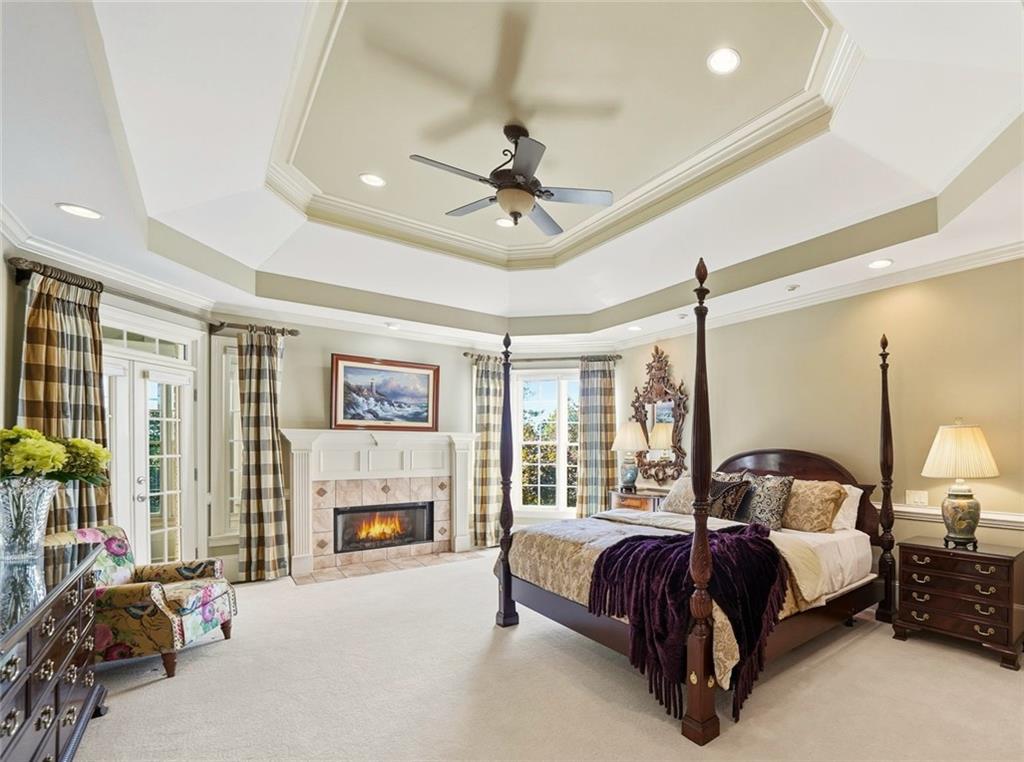 2855 Strathmore Drive Cumming, GA 30041 - Photo 34 of 96 a spacious bedroom with a balcony a bed and a fireplace