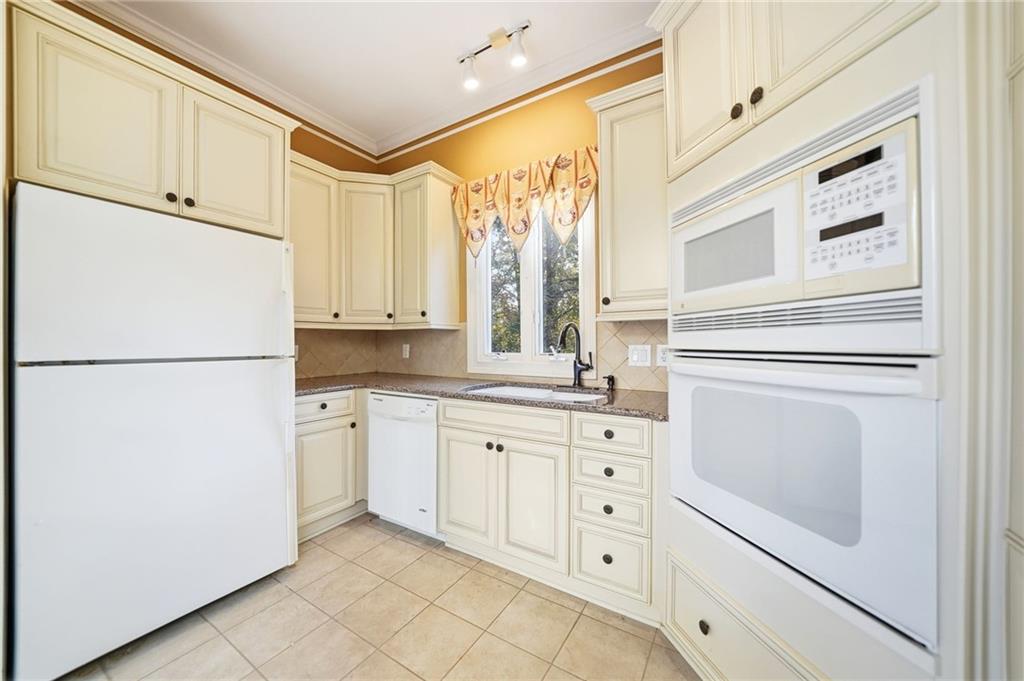 2855 Strathmore Drive Cumming, GA 30041 - Photo 77 of 96 a kitchen with white cabinets and white appliances
