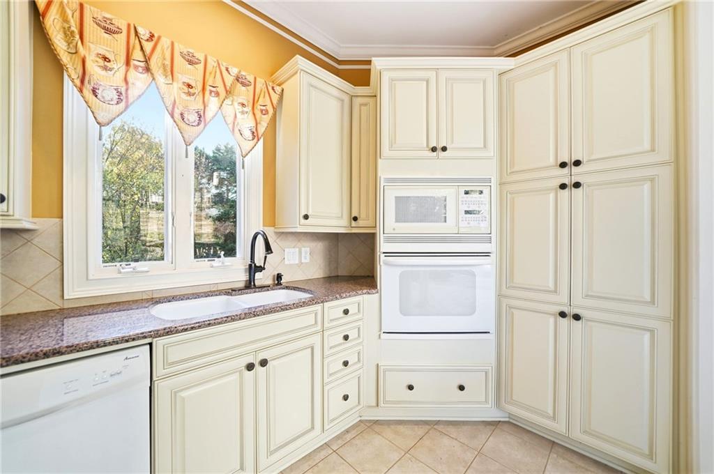 2855 Strathmore Drive Cumming, GA 30041 - Photo 78 of 96 a kitchen with granite countertop white cabinets and white appliances