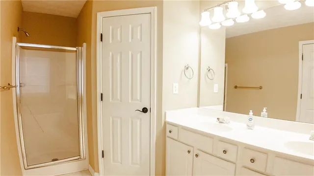a bathroom with a double vanity sink and mirror with shower
