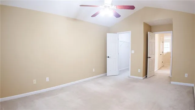 an empty room with chandelier fan and window