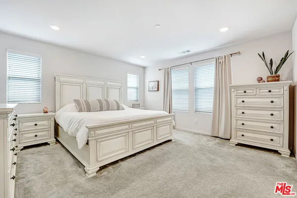 a spacious bedroom with a bed and a window