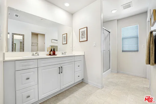 a spacious bathroom with 2 sink and a mirror