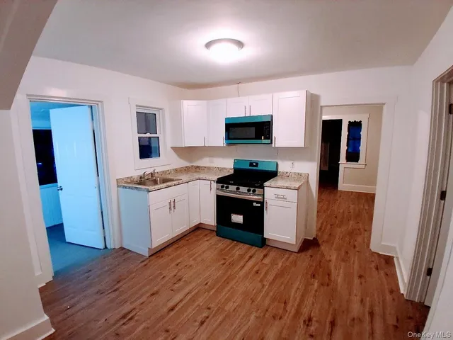 a kitchen with stainless steel appliances granite countertop a stove a microwave and a sink