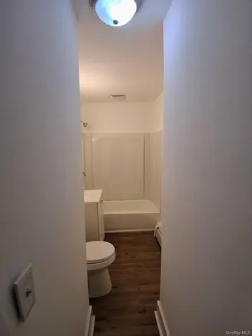 an empty room with wooden floor and window