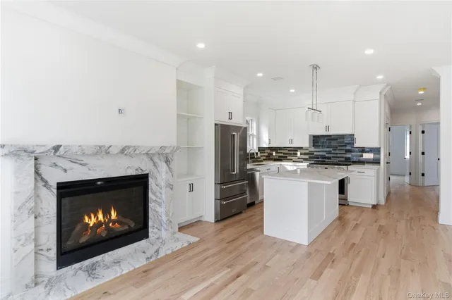 a view of a kitchen with a sink a fireplace and a window